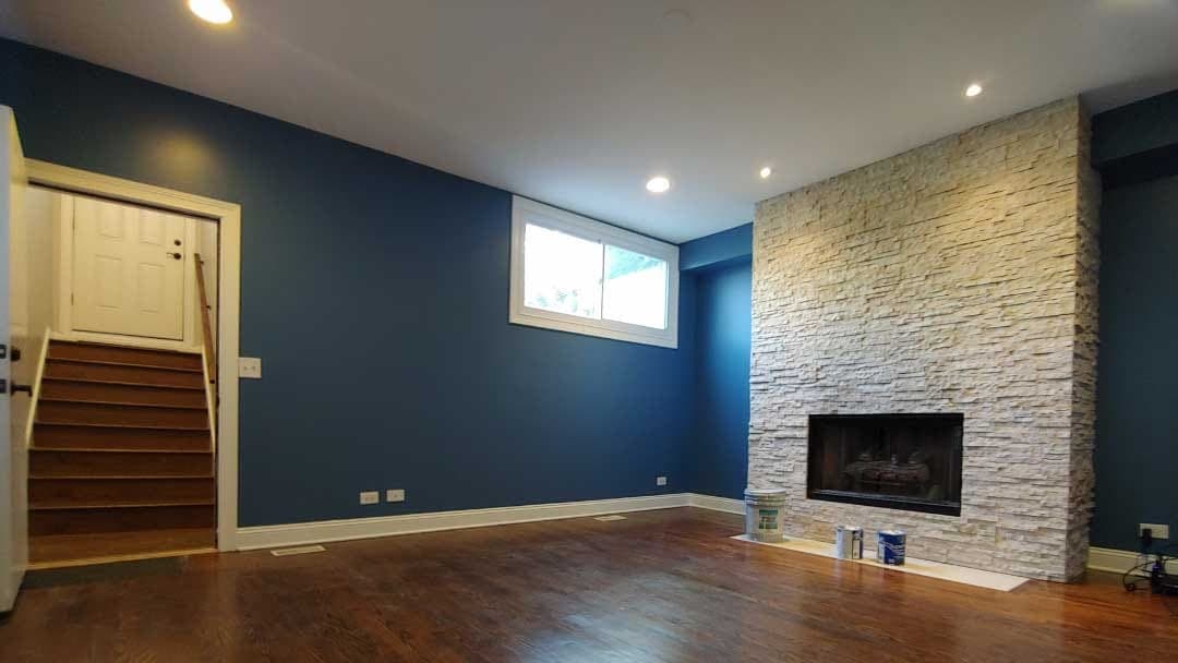 Finished deep blue living room with stone fireplace
