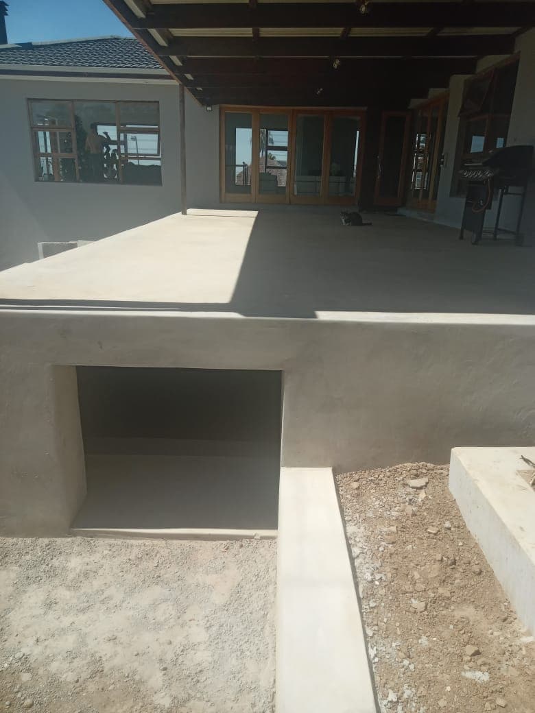 Freshly skimmed patio wall and floor with smooth grey cement finish